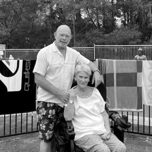 A man standing next to his wife who is a power drive wheelchair user